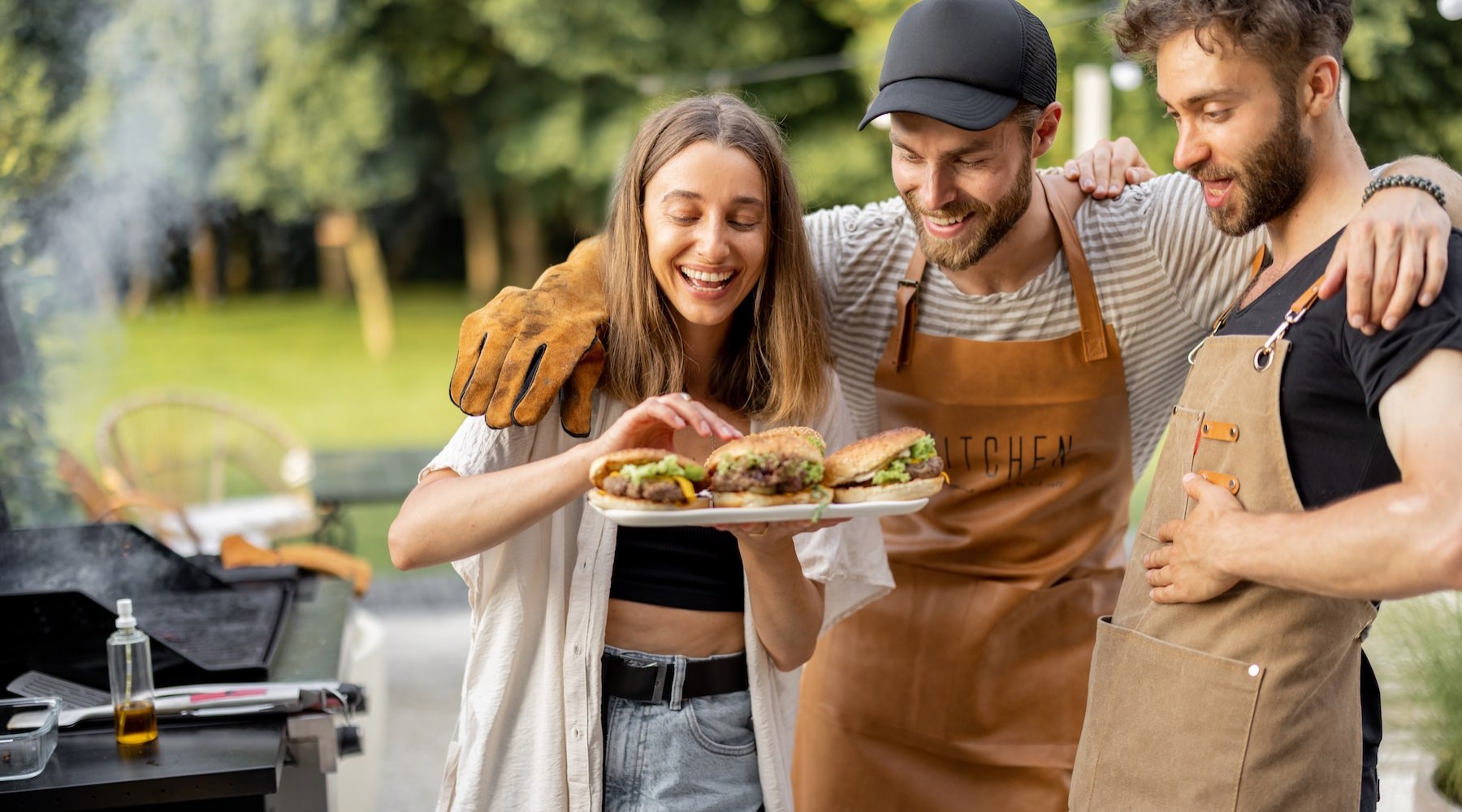 three people holding a plate of burgers
